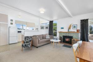 a living room with a couch and a fireplace at Kakanui Ocean Views in Kakanui