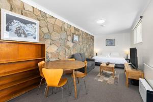 a bedroom with a bed and a table in a room at Rock On Studio in Jindabyne