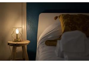 a bed with a lamp and a table with a candle at L'Essentiel Confort moderne - équipements premium et tram à 5 minutes in Strasbourg
