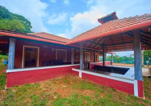 a red house with a red roof at Celestial Heights Coorg by VOYE HOMES with Sunset views-Near to Nagarhole Tiger Reserve in Srimangala +110 photos