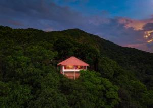 a small building in the middle of a mountain at Celestial Heights Coorg by VOYE HOMES with Sunset views-Near to Nagarhole Tiger Reserve in Srimangala