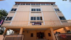 a tall white building with a sign on it at Gravity Groups Core - Sakthi residency in Puducherry Airpoert