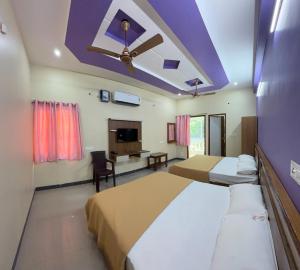 a bedroom with two beds and a ceiling fan at Gravity Groups Core - Sakthi residency in Puducherry Airpoert