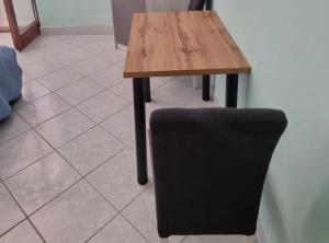 a wooden table and a chair next to a tile floor at Apartments Blink in Orebić