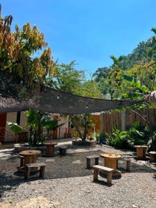 a group of benches in a park with trees at Pugad Hostel, El Nido in El Nido