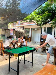 a man playing a game of pool on a table at Pugad Hostel, El Nido in El Nido