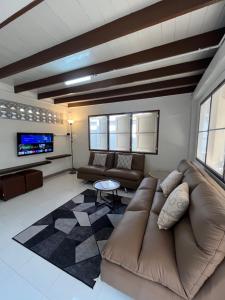 a living room with a couch and a tv at The Neighbors in Chanthaburi