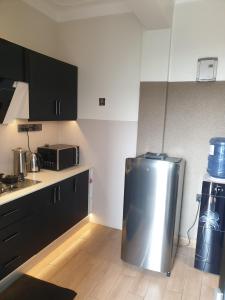 a kitchen with a stainless steel refrigerator in it at Mzuri Homes in Kampala