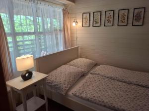 a bedroom with a bed with a lamp and a window at Agyagos Vendégház in Eger