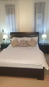 a large white bed with pillows on top of it at Mzuri Homes in Kampala