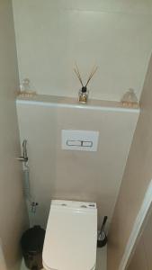 a bathroom with a white toilet with a shelf above it at Mzuri Homes in Kampala +19 photos