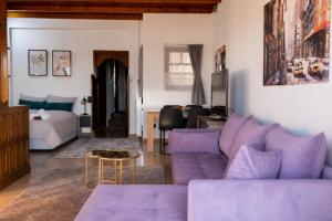 a living room with a purple couch and a bed at Stathohouse - Peaceful Balcony Retreat in Filiatra in Filiatra
