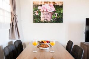 a table with a bowl of fruit and two wine glasses at Stathohouse - Peaceful Balcony Retreat in Filiatra in Filiatra