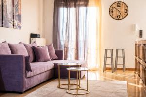 a living room with a purple couch and two stools at Stathohouse - Peaceful Balcony Retreat in Filiatra in Filiatra