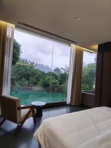 a bedroom with a large window with a view of a river at Yipin Noble Residence in Xinxu