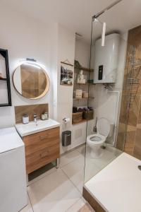 a bathroom with a toilet and a glass shower at Appartement central - L'est in Tarare +7 photos