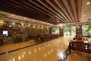 a restaurant with tables and a bar in a room at Thimura Resort in Bharatpur