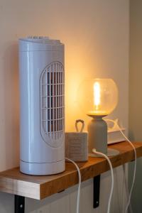 a heater on a wooden shelf next to a lamp at Appartement central - L'est in Tarare
