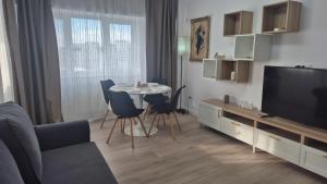 a living room with a television and a table and chairs at Unirii Residence in Bacău