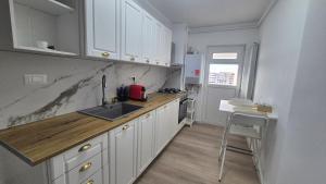a kitchen with white cabinets and a sink and a counter at Unirii Residence in Bacău