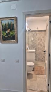 a bathroom with a painting of a dog on the wall at Unirii Residence in Bacău