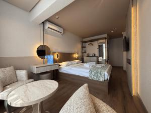 una camera d'albergo con un letto, un tavolo e delle sedie di Aterna Hotel a Dikili Altre 26 foto