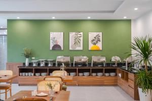 a restaurant with green walls and tables and chairs at Nature Hotel - Le Hong Phong in Da Lat +67 photos