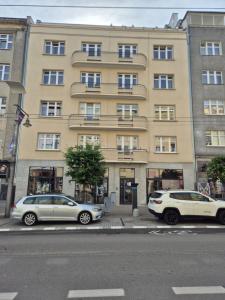 two cars parked in front of a large building at SHIRE Gdynia in Gdynia