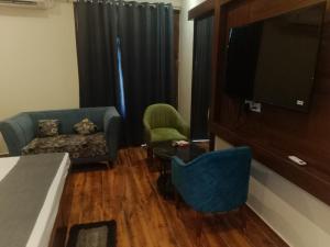 a living room with a couch and a flat screen tv at Hotel Harmony in Kharar