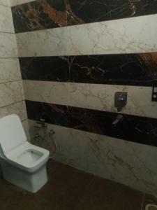 a bathroom with a toilet and black and white tiles at Hotel Harmony in Kharar