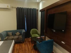 a living room with a couch and a flat screen tv at Hotel Harmony in Kharar +5 photos