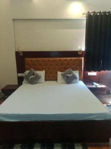 a large bed with two pillows on top of it at Hotel Harmony in Kharar