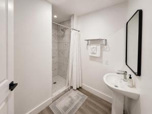 a white bathroom with a shower and a sink at Sun Valley Motel in Phoenix