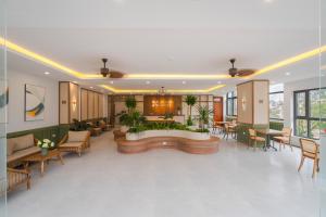 a lobby with a waiting area with tables and chairs at Nature Hotel - Le Hong Phong in Da Lat