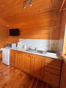 a kitchen with a sink and a stove at Cztery Pory Roku in Sarbinowo +46 photos