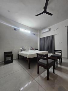 a bedroom with a bed and a chair and a ceiling fan at Brahma Heritage Resort in Pushkar