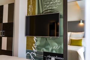 Ein Flachbildfernseher, der an einer Wand im Schlafzimmer hängt in der Unterkunft Hotel Valentina in St Julian's