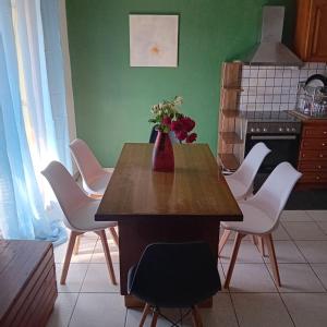 a kitchen with a table with a vase of flowers on it at Family garden house in Limenas +9 photos