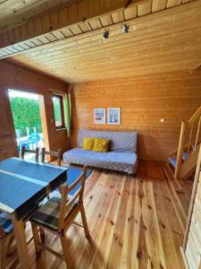 a living room with a couch and a table at Cztery Pory Roku in Sarbinowo