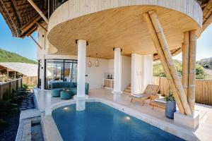 an indoor swimming pool in a house with a wooden ceiling at Buenavista Lux Villas in Kuta Lombok