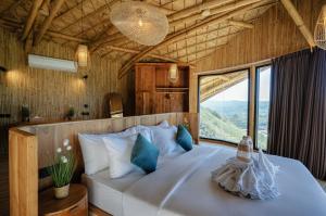 a bedroom with a large bed with a large window at Buenavista Lux Villas in Kuta Lombok +15 photos