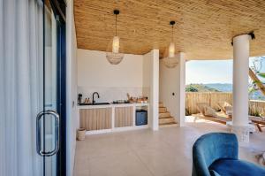 a kitchen and living room with wooden ceilings at Buenavista Lux Villas in Kuta Lombok