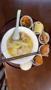 a plate with a bowl of soup and a spoon at Yipin Noble Residence in Xinxu