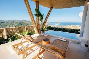 a patio with a table and chairs and a swimming pool at Buenavista Lux Villas in Kuta Lombok