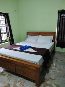 a bed with a blue pair of shoes sitting on it at Bridgettine Paradise 2 in Kalpetta