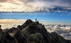 a person standing on the top of a mountain at Dovolenkový dom Čerešňový Sad in Vysoké Tatry