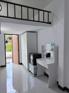 a white room with a desk and a window at บ้านสวนชมจันทร์ กำแพงแสน in Ban Song Hong