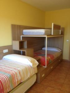 - une chambre avec deux lits superposés et un lit dans l'établissement Apartaments la Fabrica, à Horta de San Joan