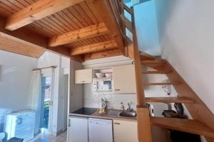 a kitchen with a staircase in a tiny house at Cozy apartment with lake view in Gérardmer