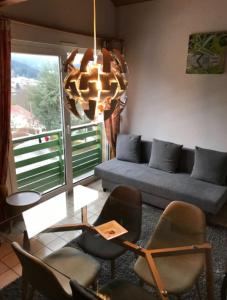 a living room with a couch and chairs and a chandelier at Cozy apartment with lake view in Gérardmer